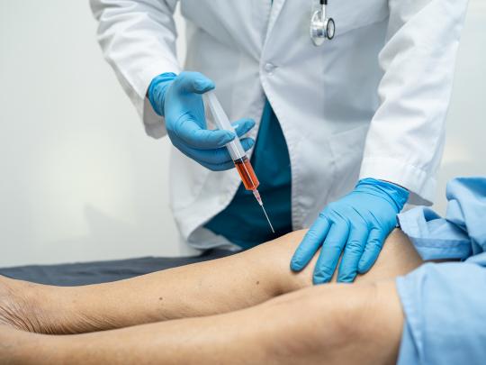 Patient receiving shockwave therapy for joint pain relief in a clinical setting